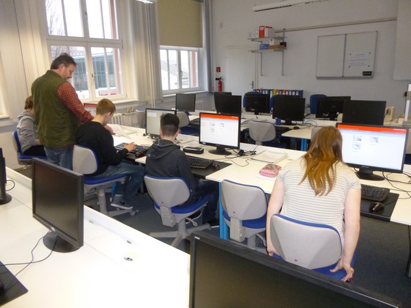 Schüler sitzen an PC-Arbeitsplätzen